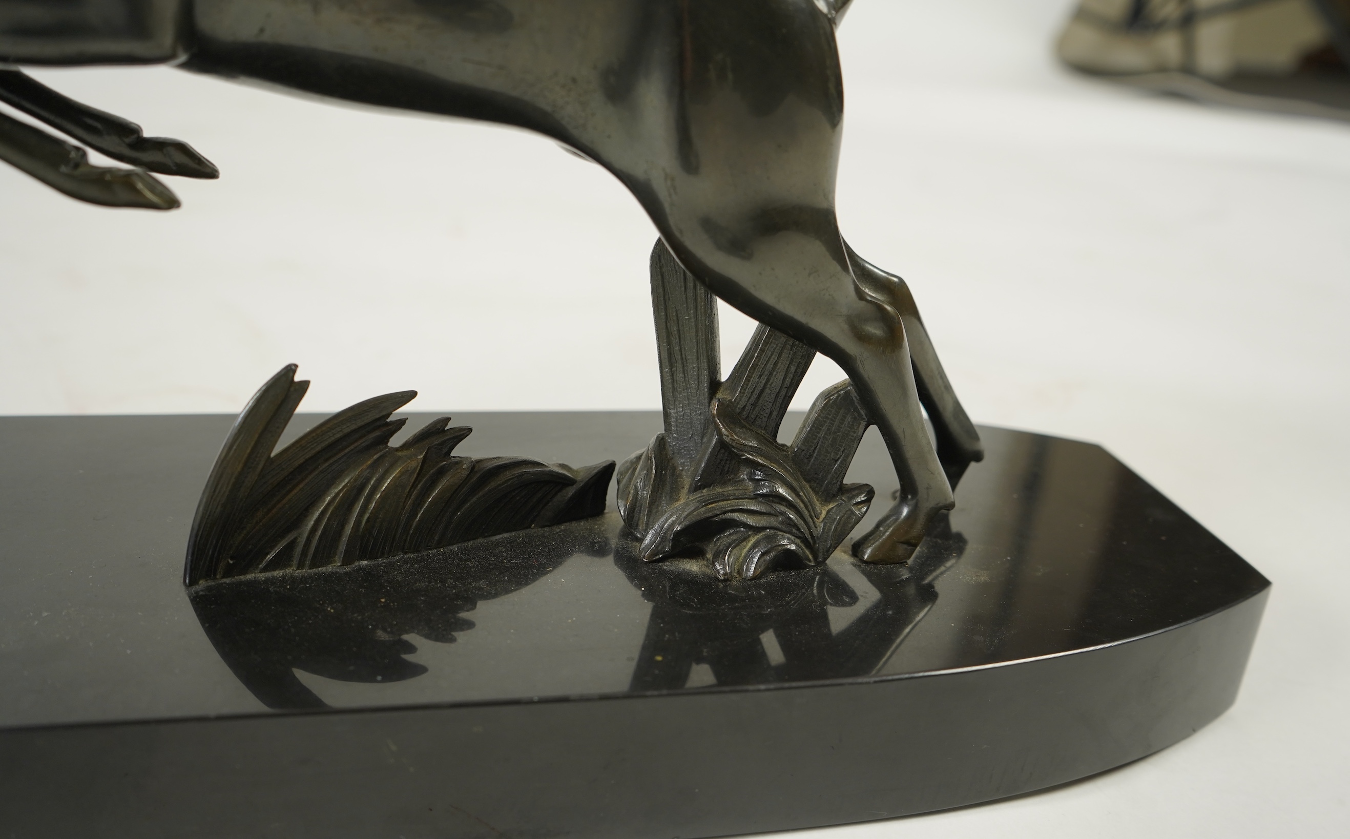 Attributed to Zoltan Kovasz (Romanian, 1883-1952), a bronzed spelter male hunter holding a chromed spear, with springbok, on a polished slate base